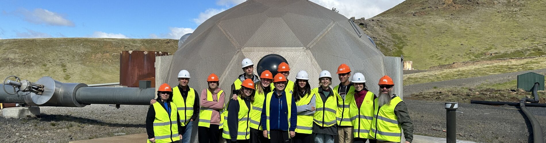 Students in safety gear standing in front of an injection well
